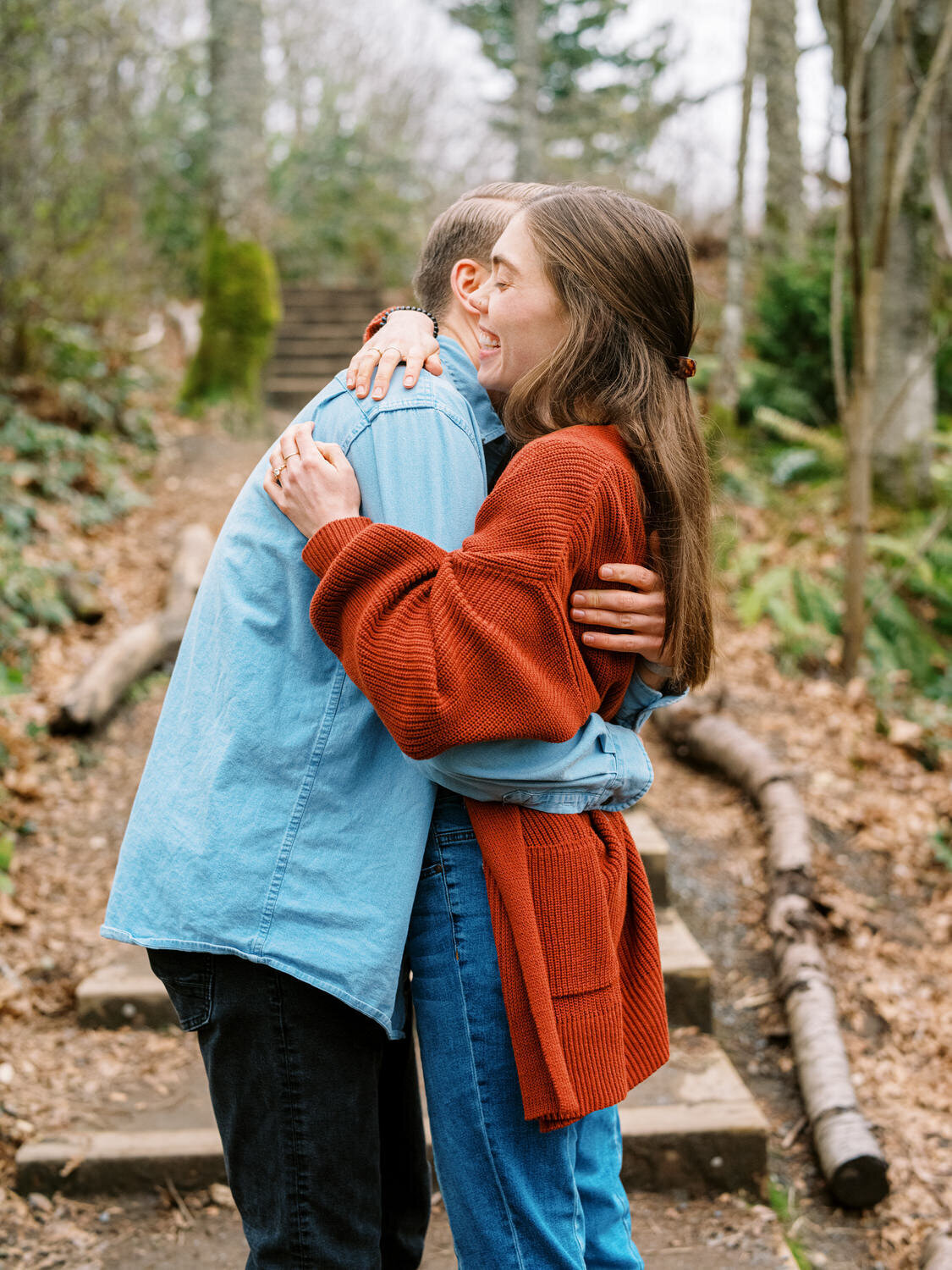 Couple hugs in the wodds during engagement photo session