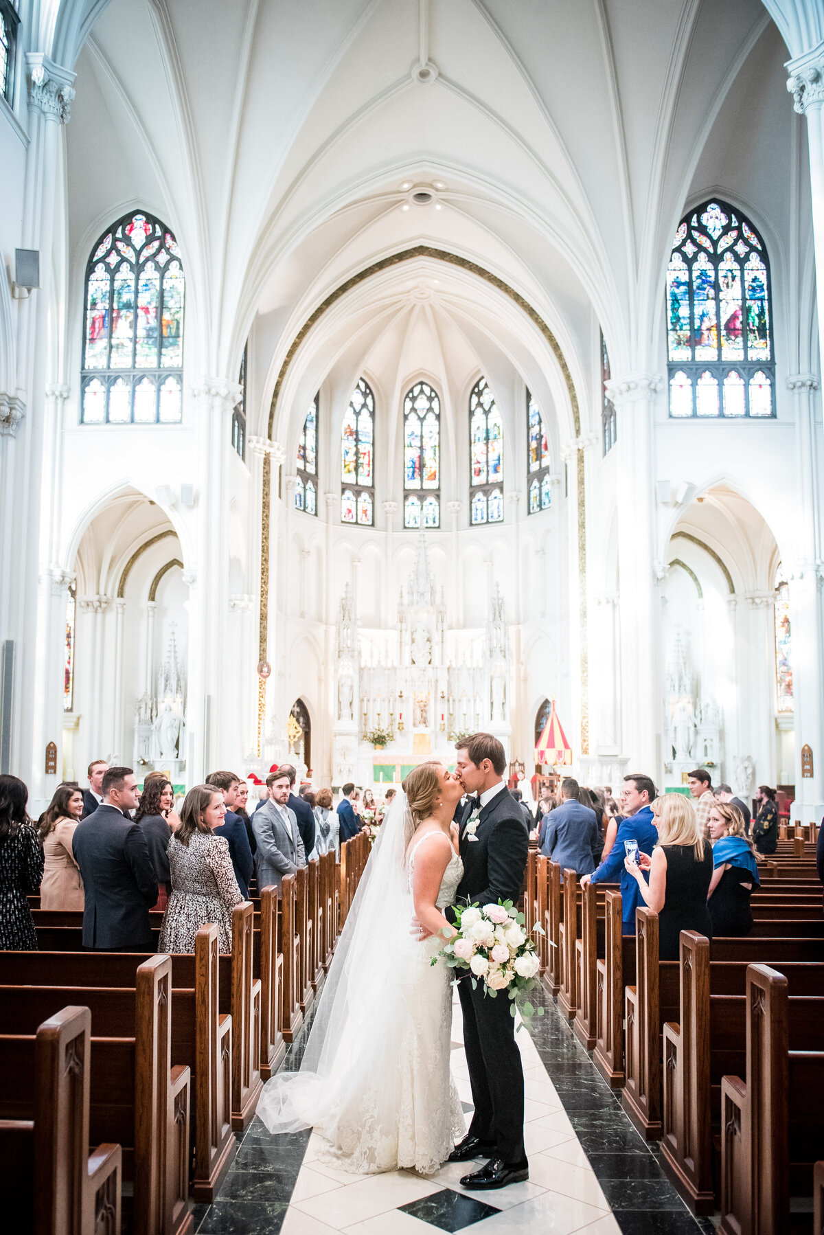 A bride and groom share a kiss at the end of the aisle after their church ceremony in Denver, Colorado.