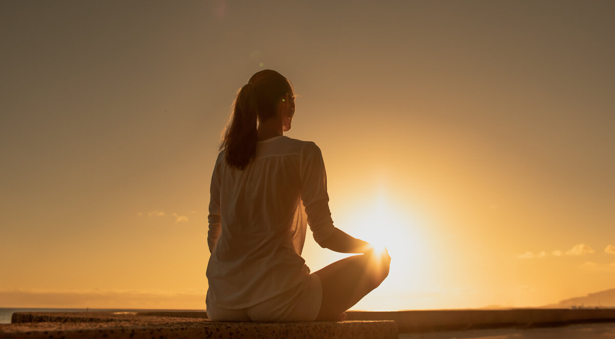 women_meditating_sunrise