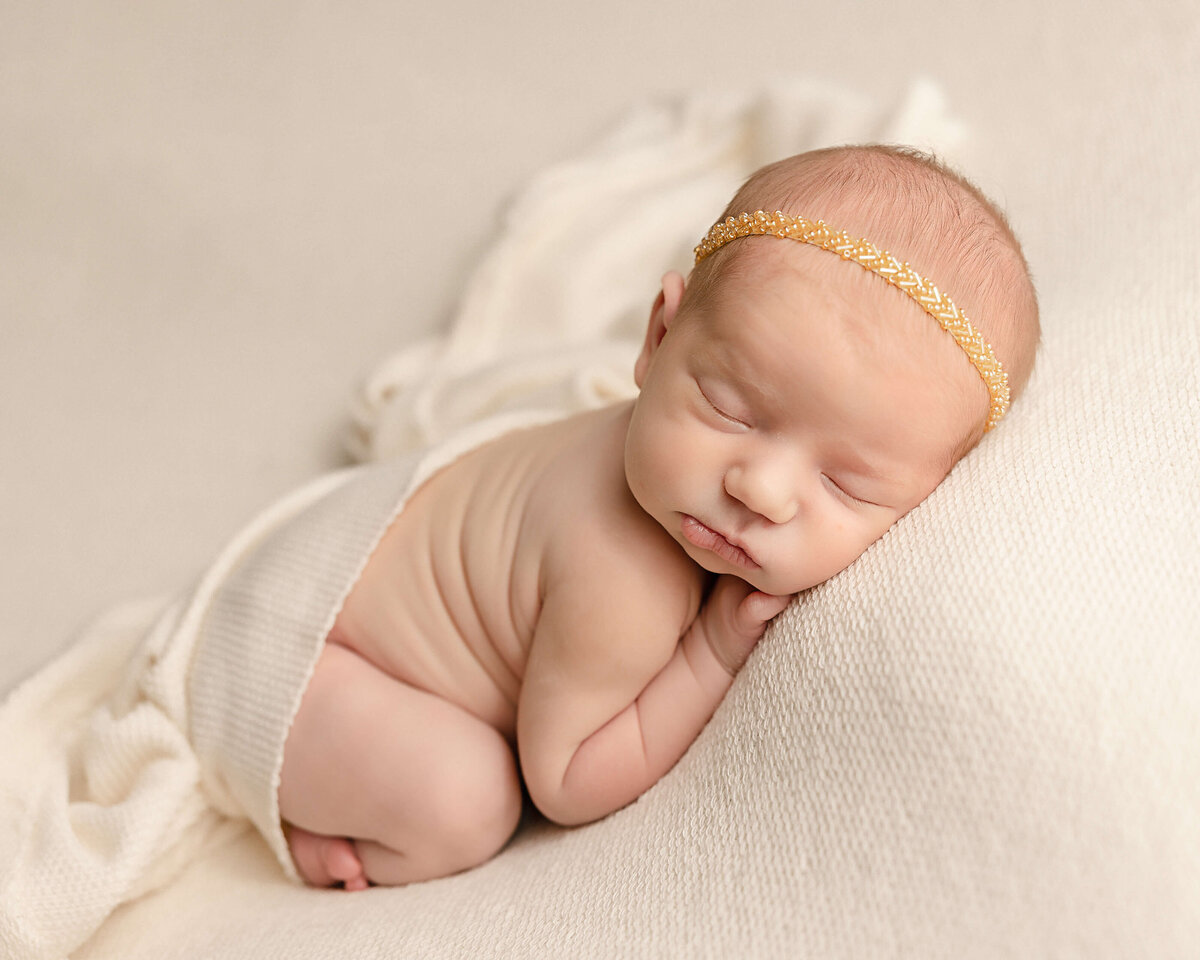 baby girl wearing gold headband with fabric covering her