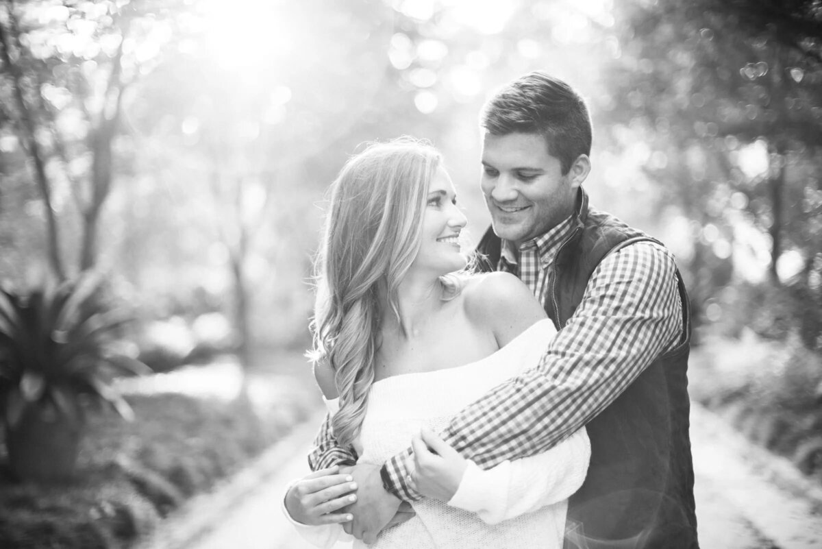 Monochrome image of a couple in a close embrace, with soft light creating a halo around them