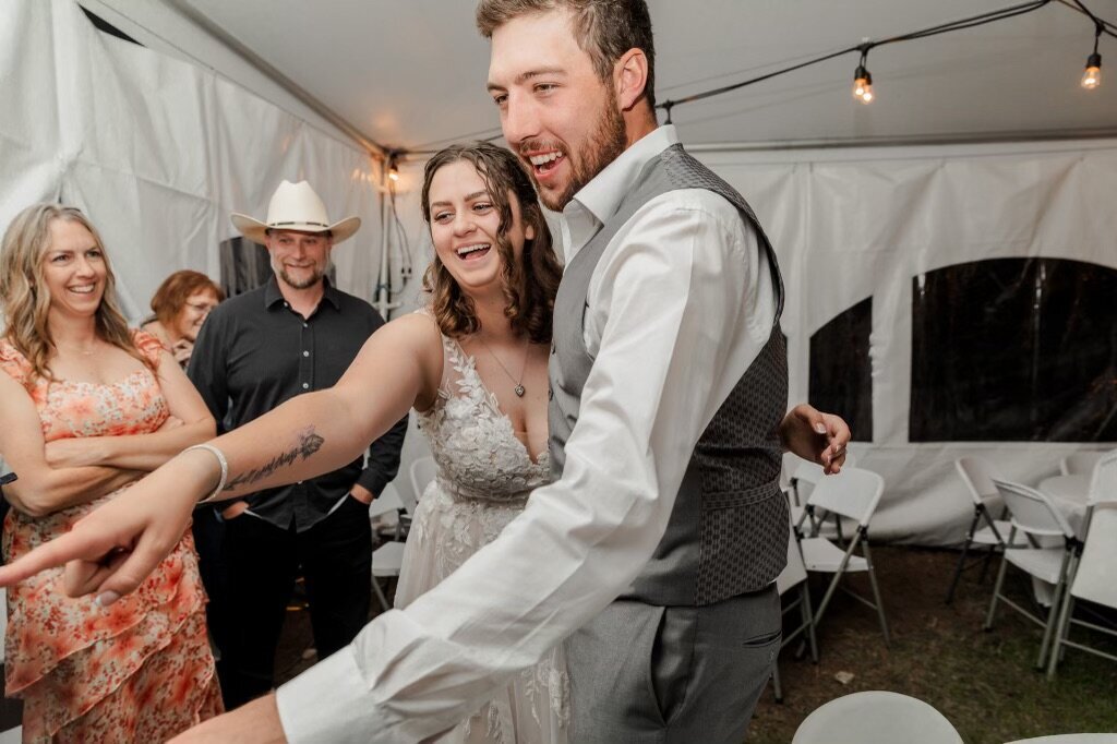 Bride and groom watching their live wedding painter at their reception for their wyoming wedding