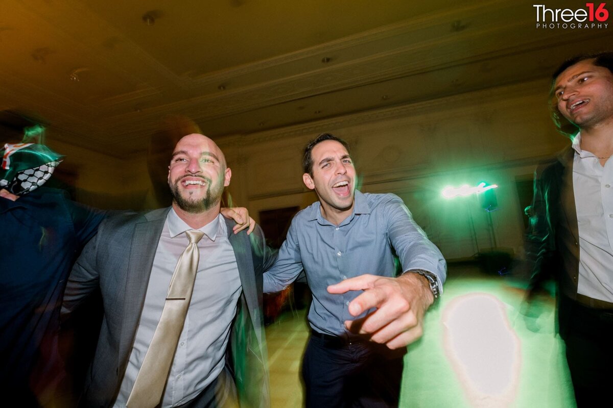 Guys ham it up for the event photographer while on the dance floor