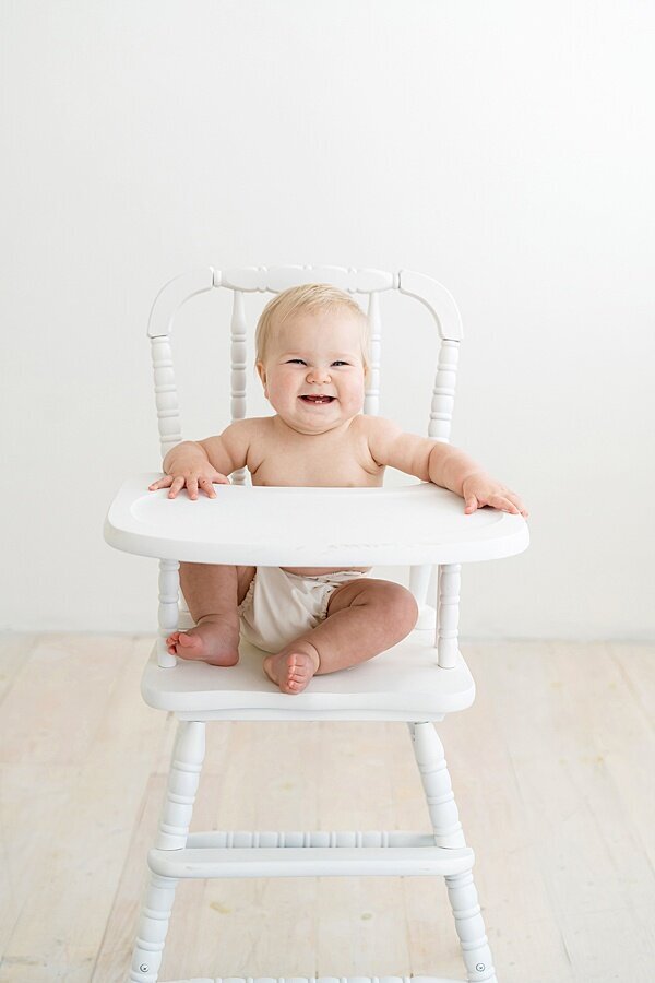 Baby in high chair sitting up by Louisville Portrait Photographer