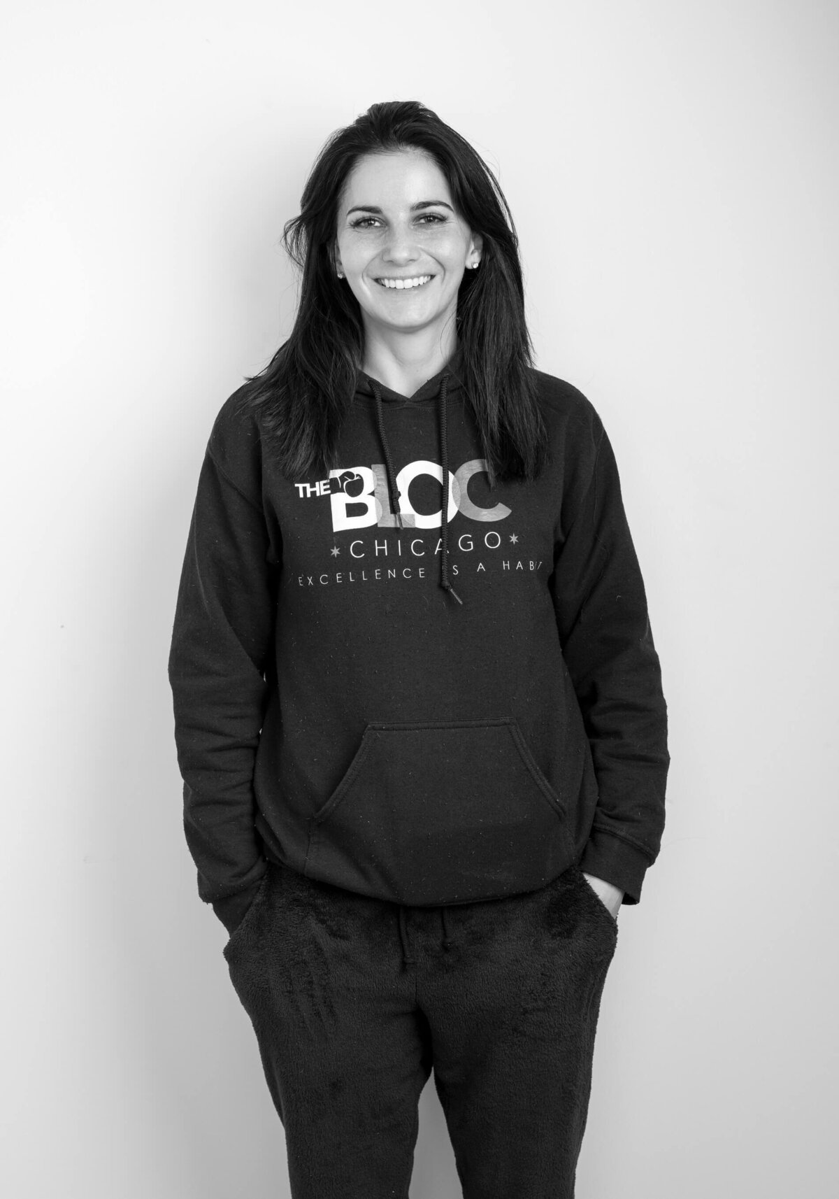 Casual before shot of a woman in a hoodie, smiling against a plain background.