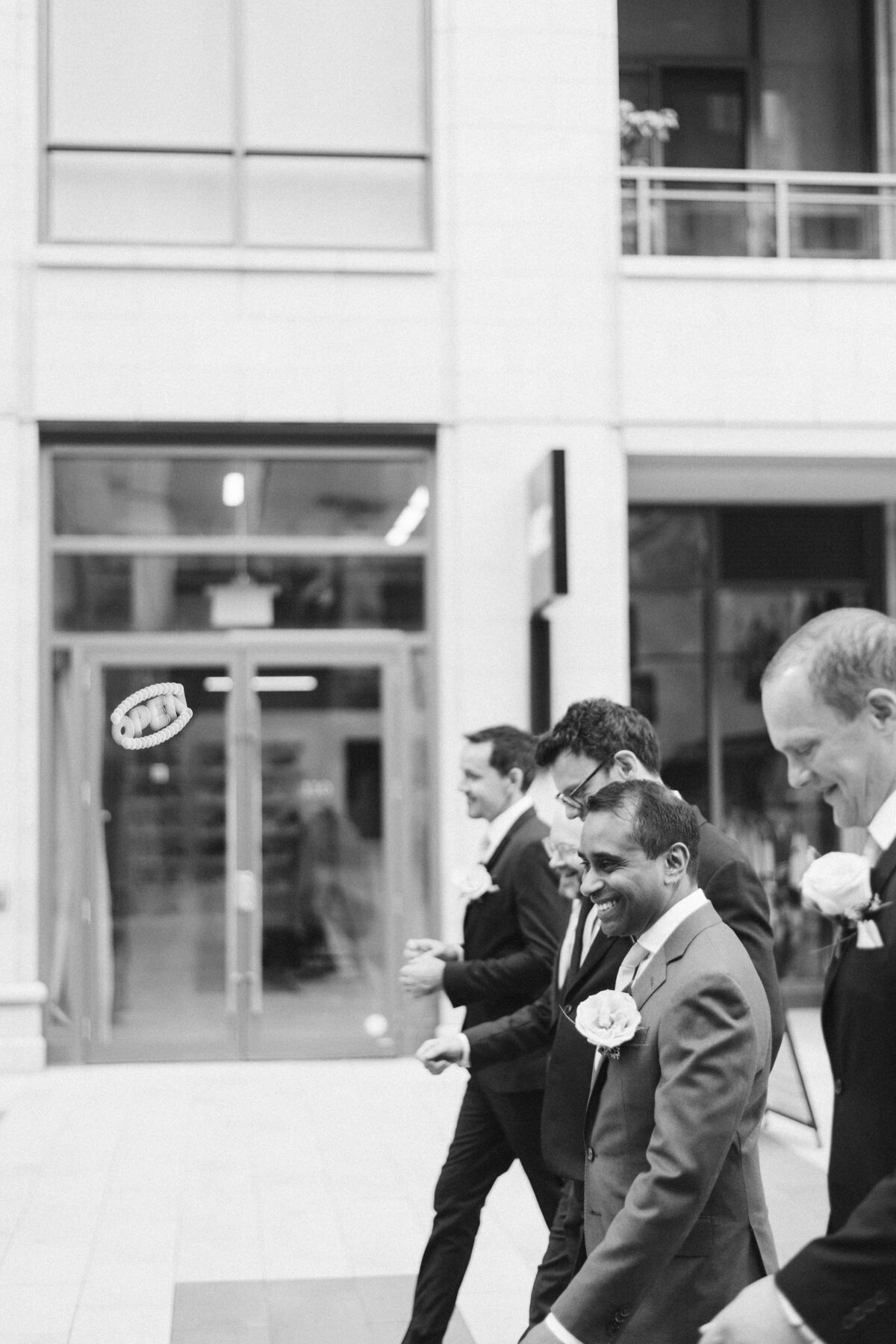 Groomsman walking in courtyard at the pearle hotel