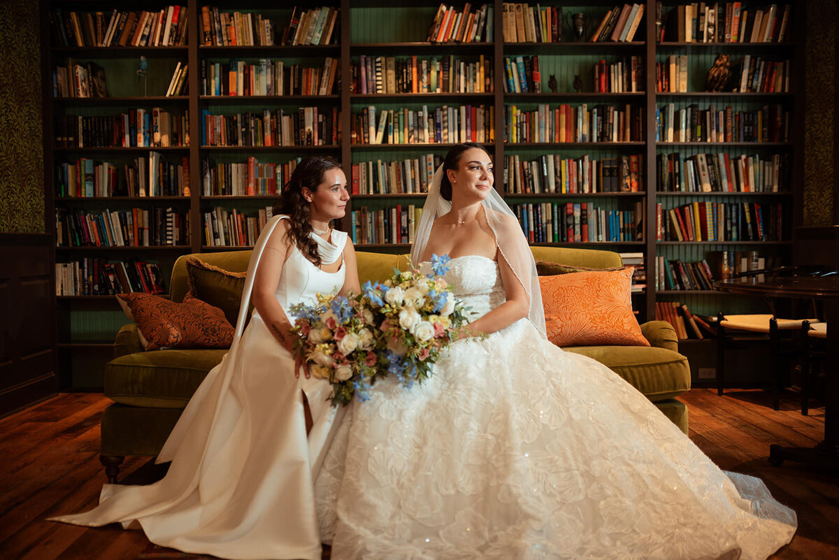 Two brides sitting in a library