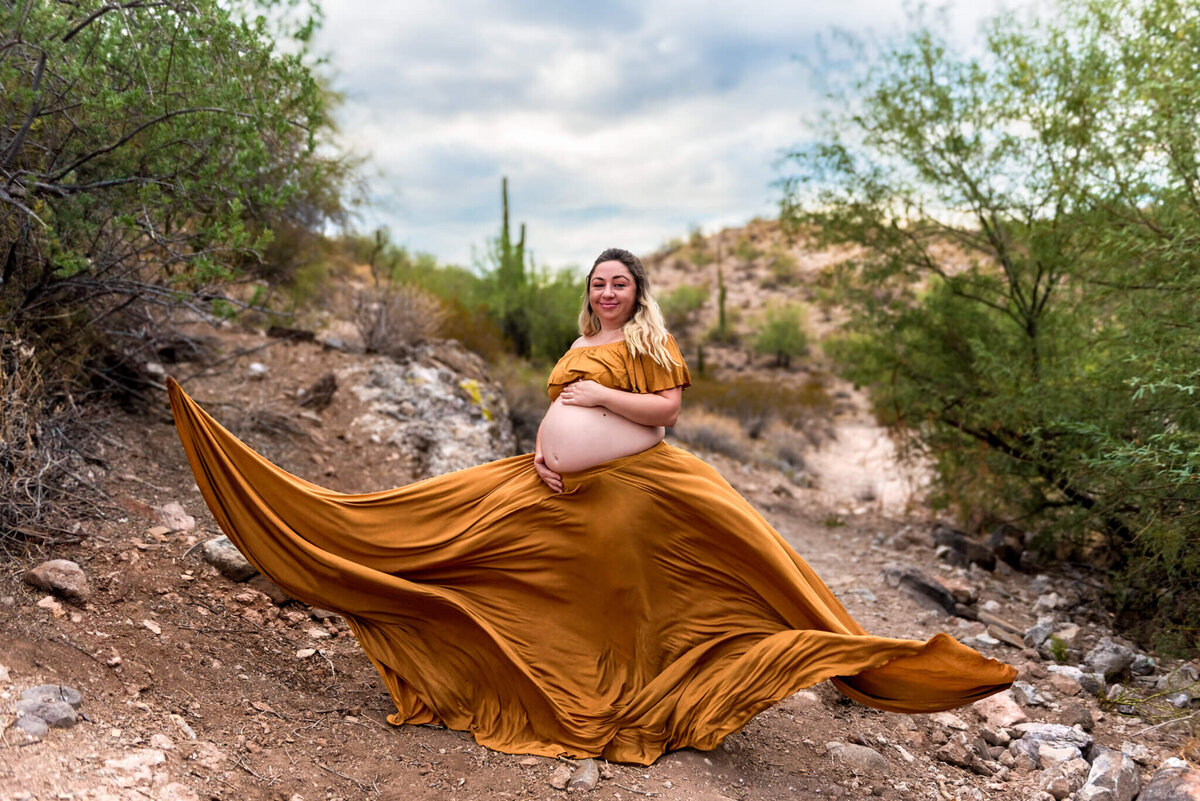 mom-to-be in yellow, long flowing dress with baby bump exposed