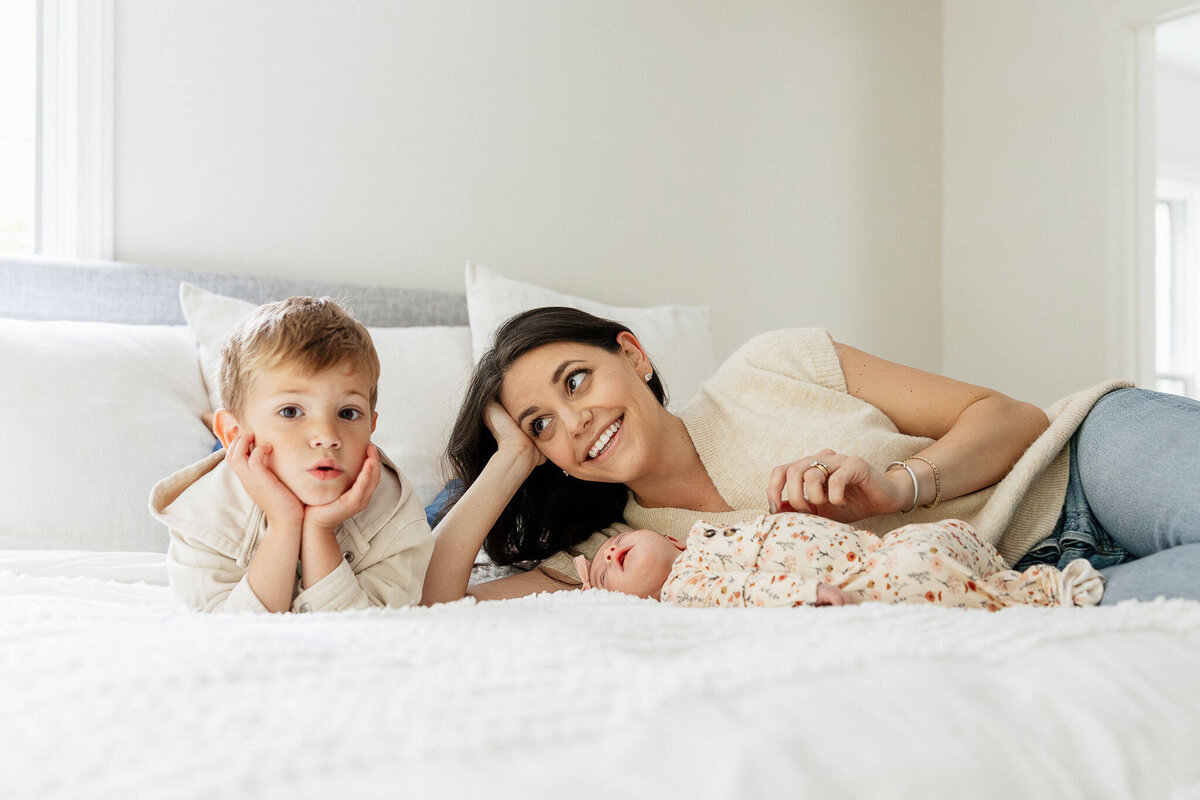 Mother and son share a quiet moment with their newborn during a lifestyle photography session in Cleveland.