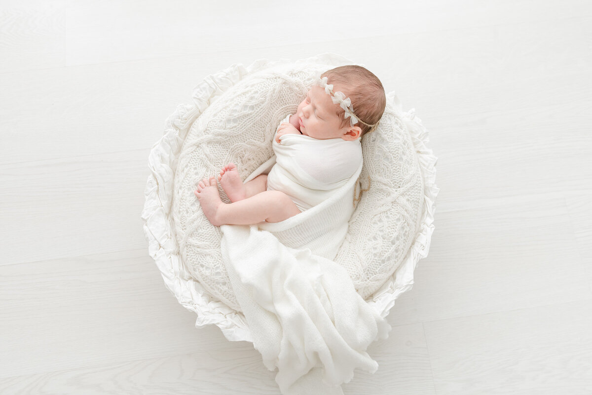 a newborn baby in a white nest