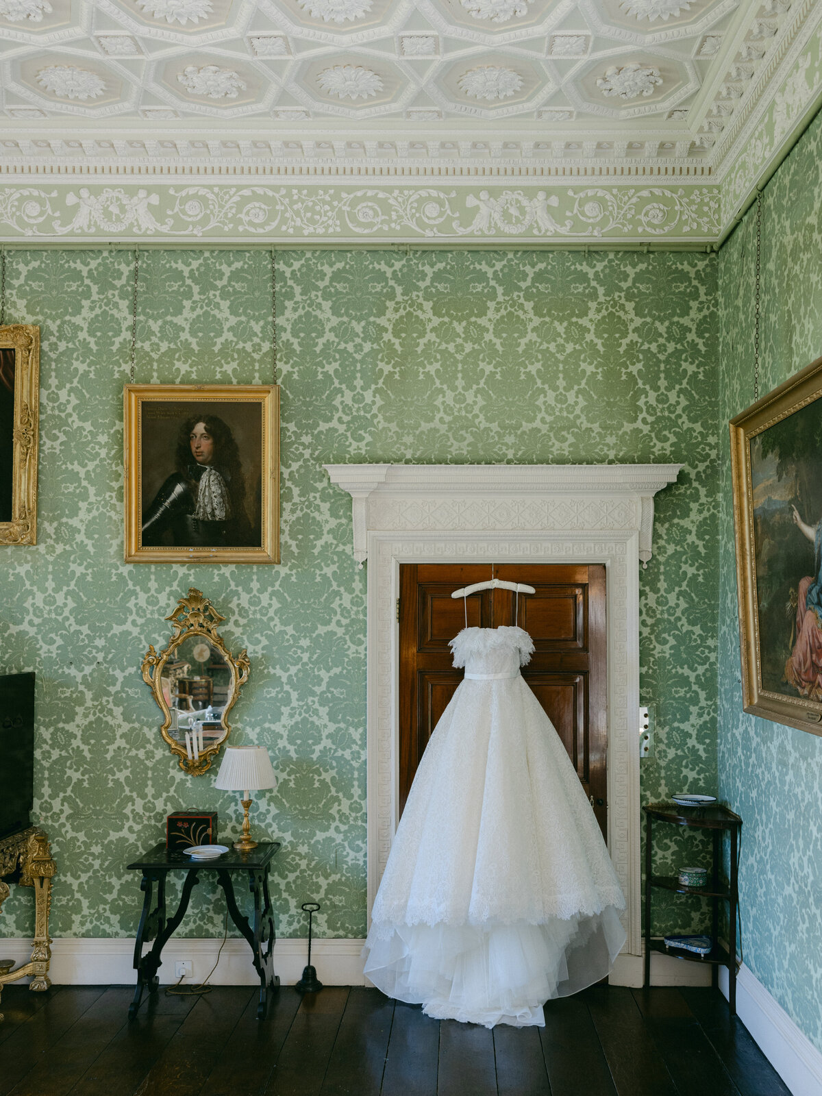 Wedding dress hanging on door British countryside wedding