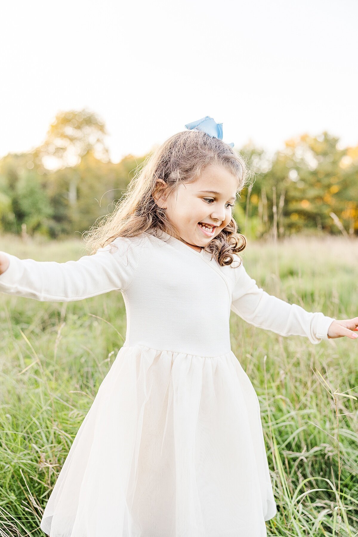 girl runs in field during Family photo session with Sara Sniderman Photography in natick massachusetts