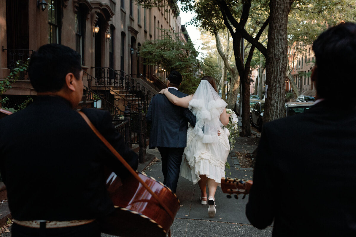 Brooklyn wedding couple walking through cobble hill with mariachi band playing