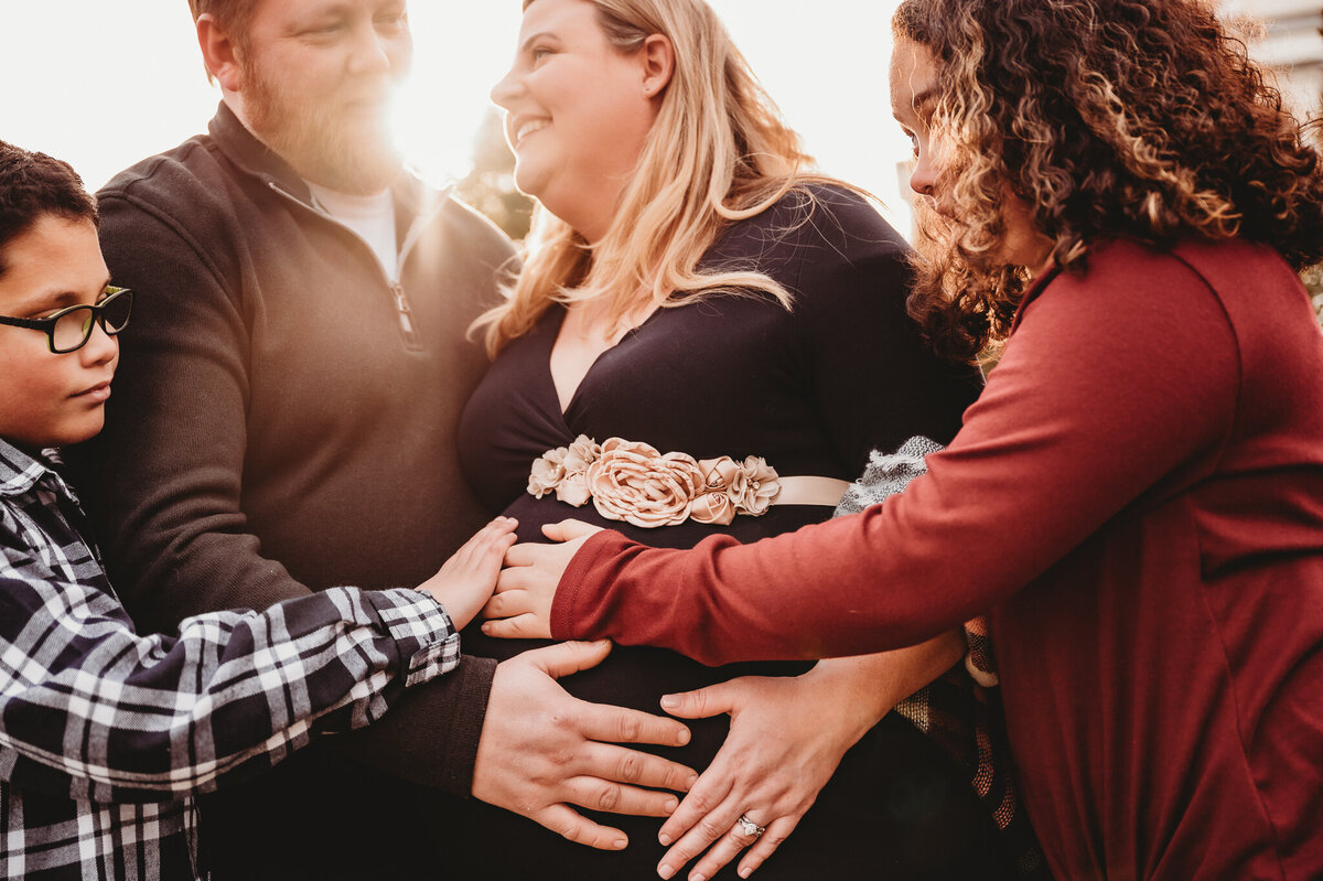Family hands on pregnant mom's belly
