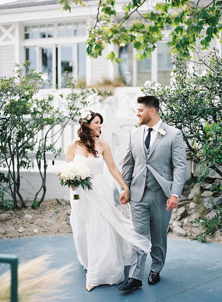 bride with white bouquet and groom with gray suit