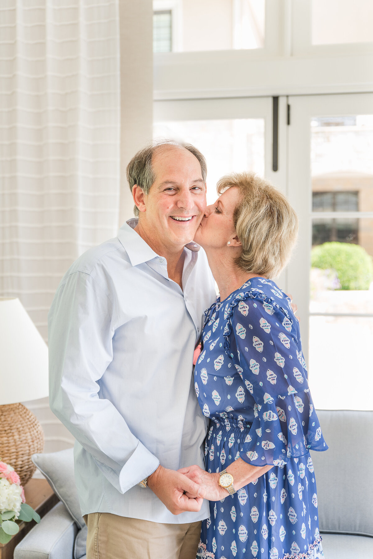 senior couple kissing cheeks wearing blue