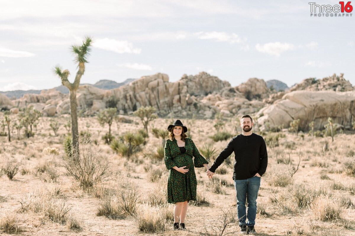 Parents to be pose in Joshua Tree National Park holding hands
