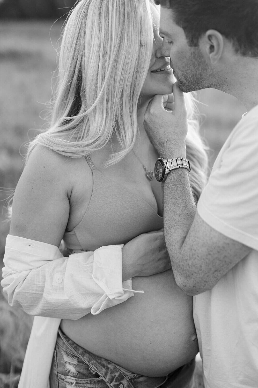couple kissing at  maternity session in Finger Lakes, New York