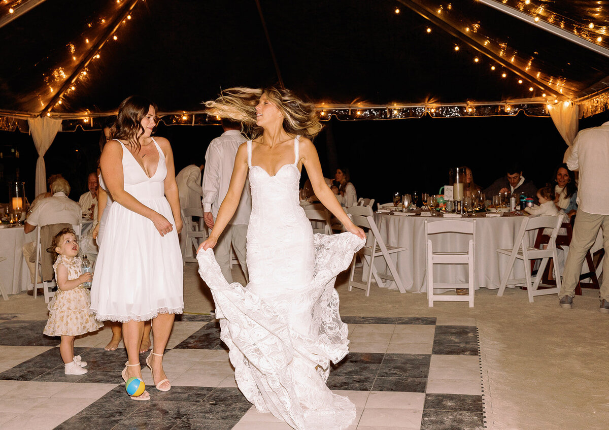 Bride Laura twirling in joy on the dance floor at her beachfront wedding reception in Miami.