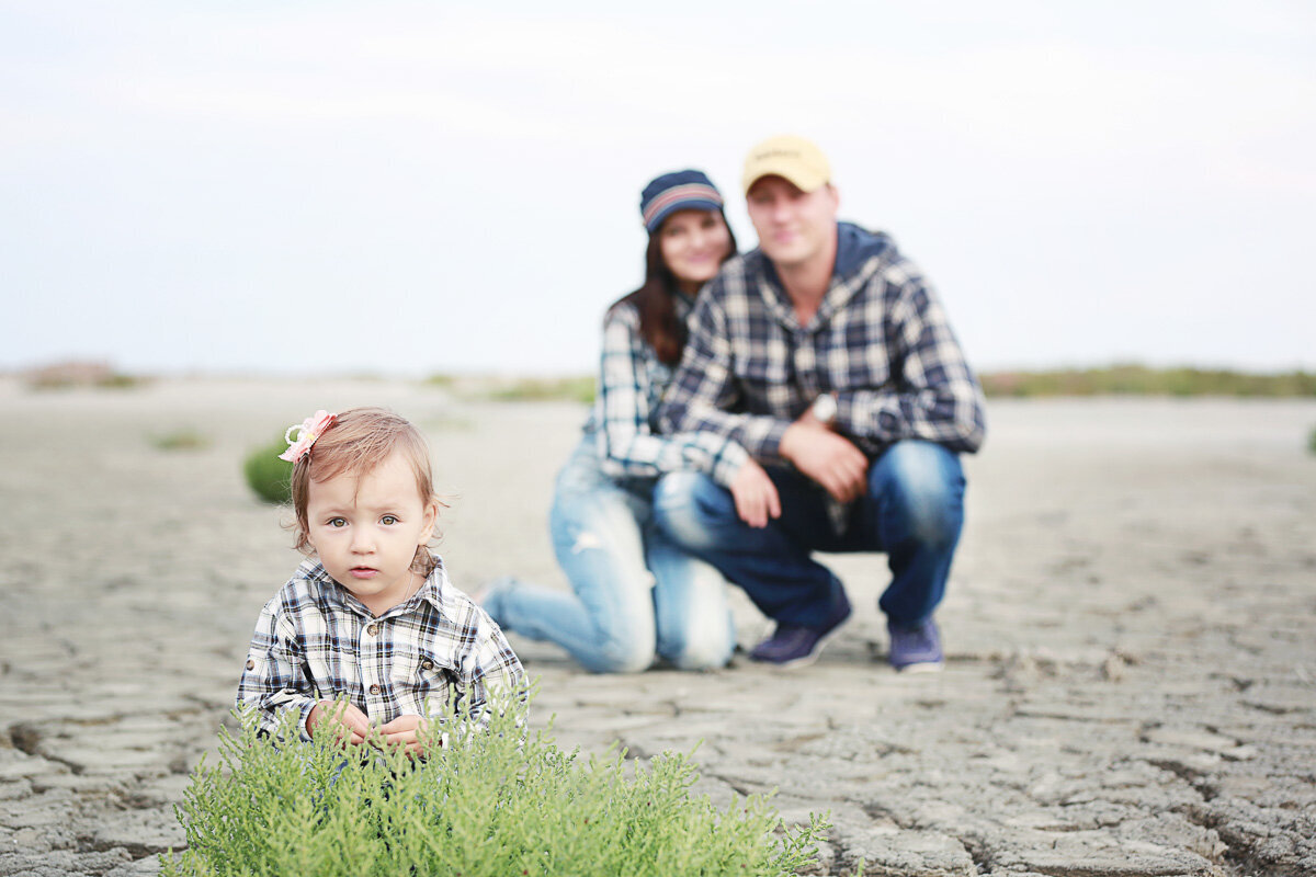 Child portrait with parents sitting on the backgrapund