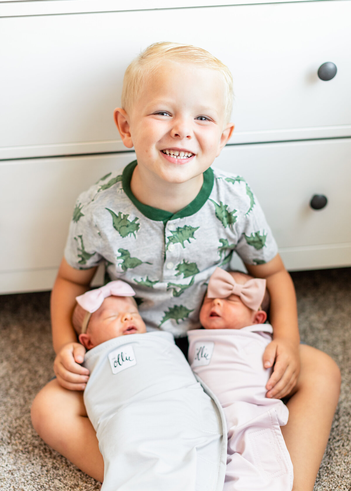 two newborn baby girls with their older brother