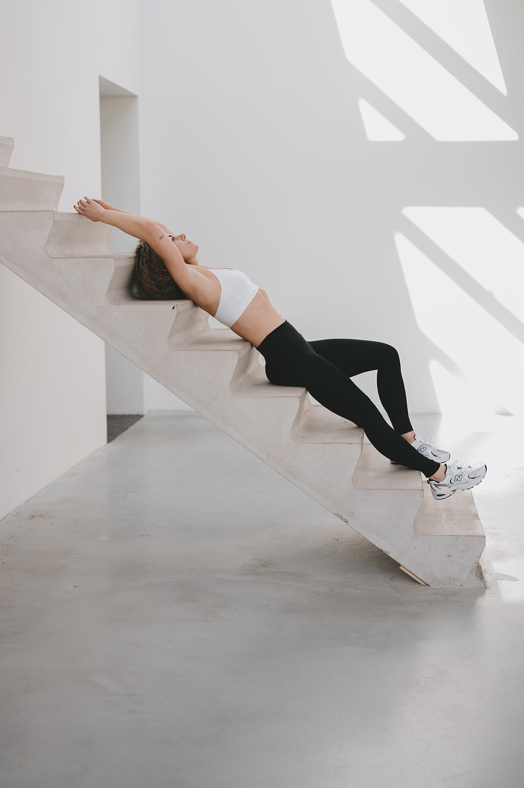vrouw in sportieve kleding liggend op trap