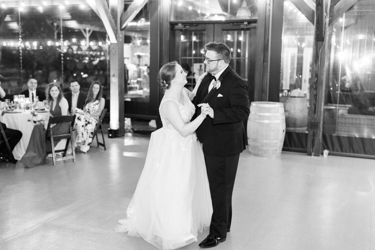 Bride and groom happily dancing on their wedding reception in a black and white photo