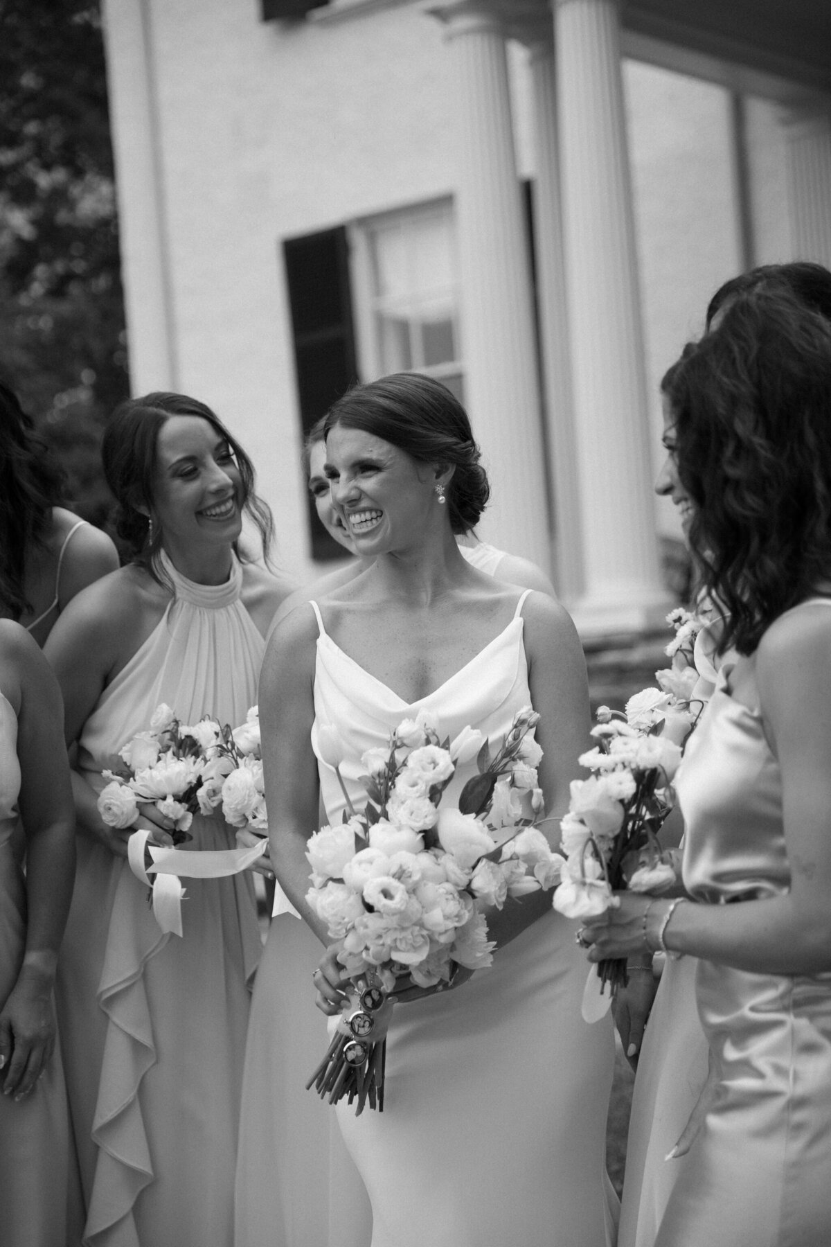 Rust Manor House Wedding | A black and white image of bride and bridesmaids laughing outside of Rust Manor House.