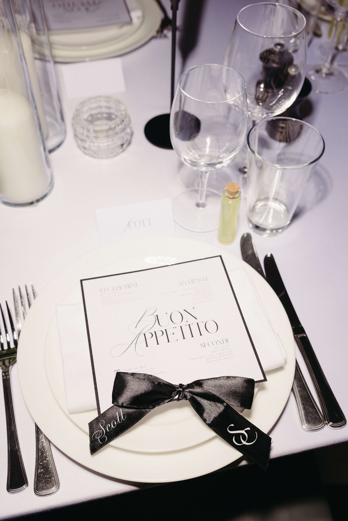 Close-up of elegant wedding place setting with monogrammed ribbon and menu