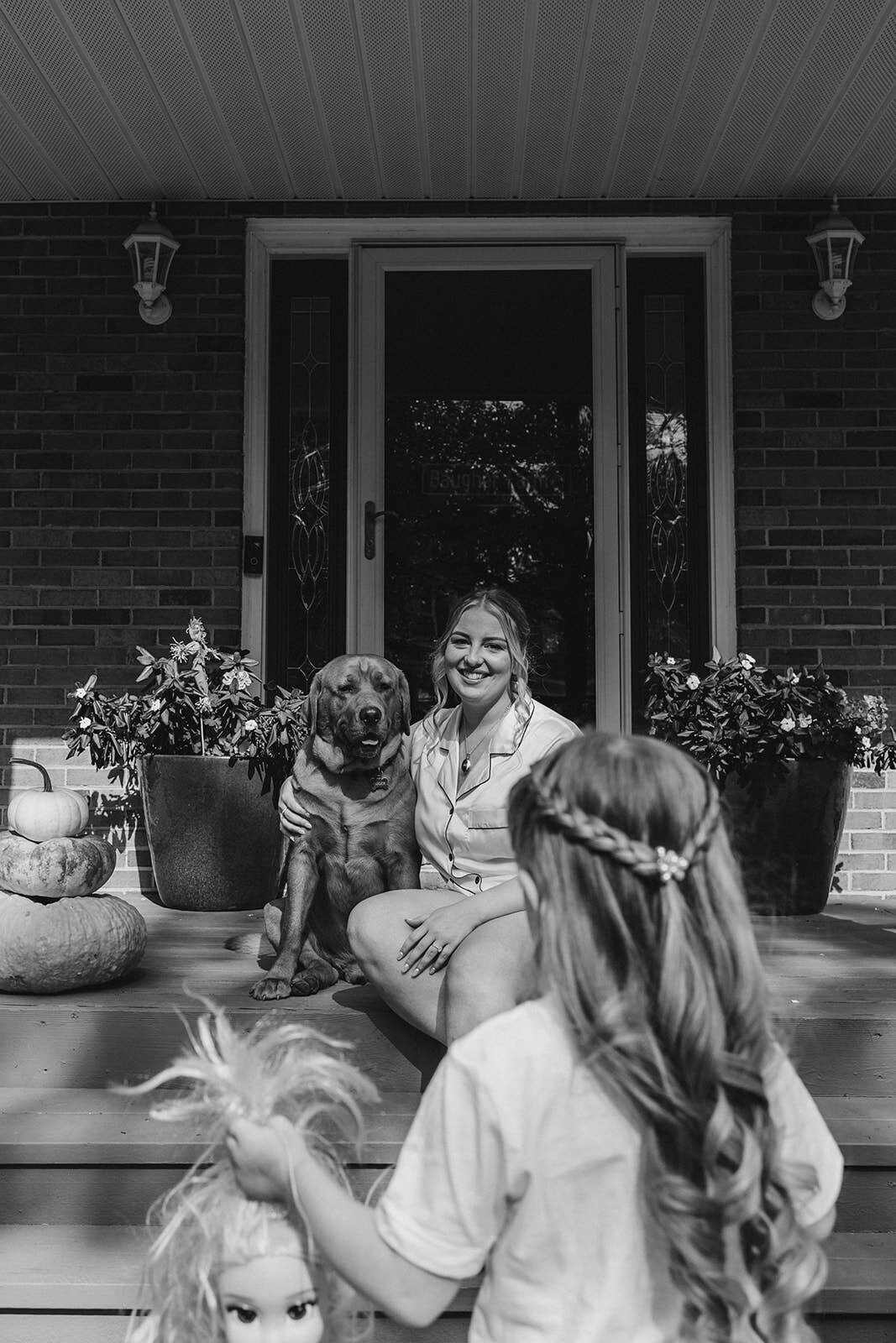 A person sitting porch steps with their dog