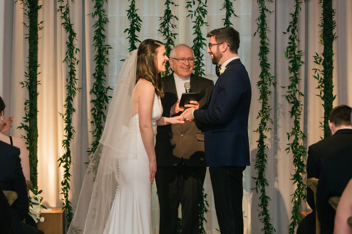 A couple shares a laugh during their wedding ceremony inside the ballroom of the Ivy Room in Chicago
