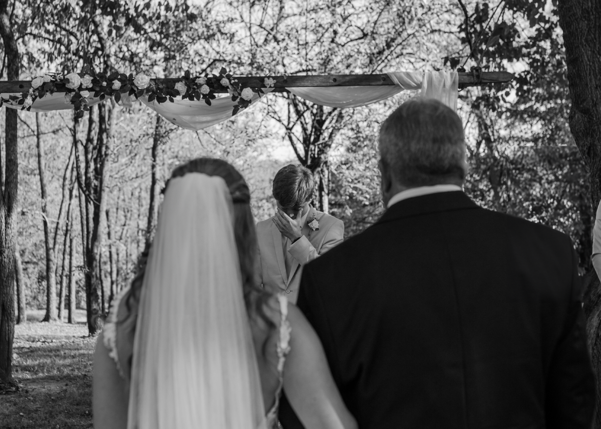 Bride and groom holding hands, black and white wedding portrait in Indiana.