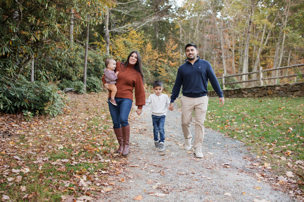 Family of four walking and smiling as they walk down the path