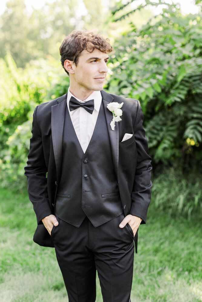 man in a tuxedo standing with his hands in his pockets