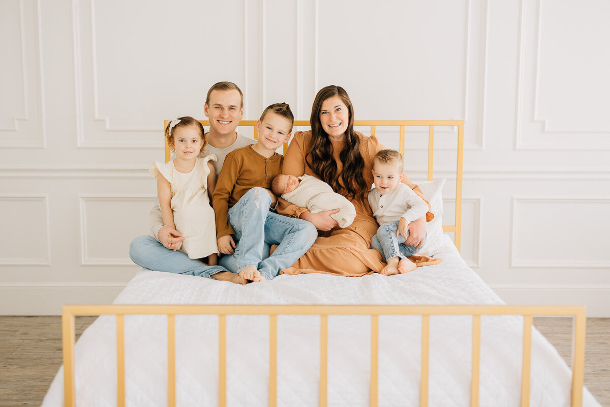 family with newborn baby smiles at their family photography studio session