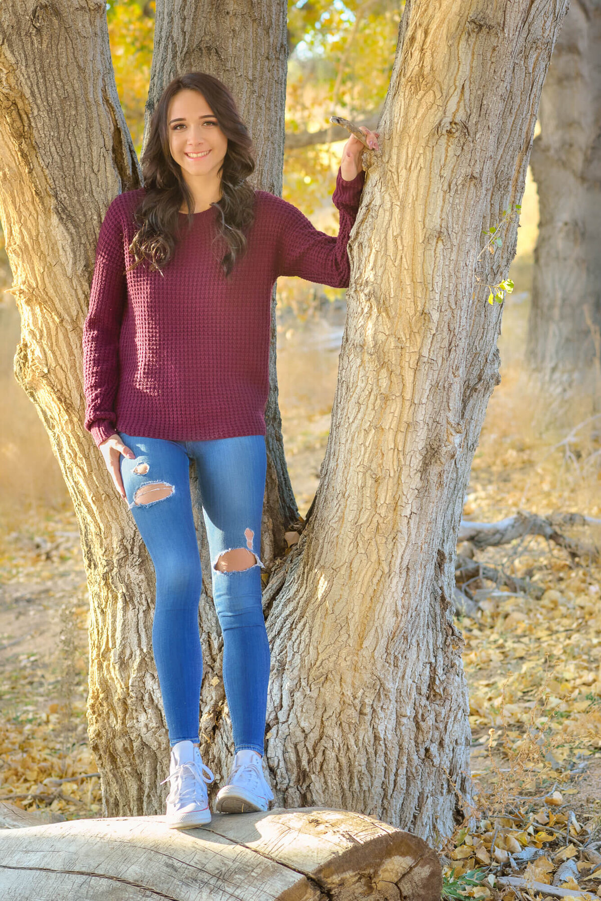 Girl poses on log by Willow Lake for Prescott senior photos with Melissa Byrne