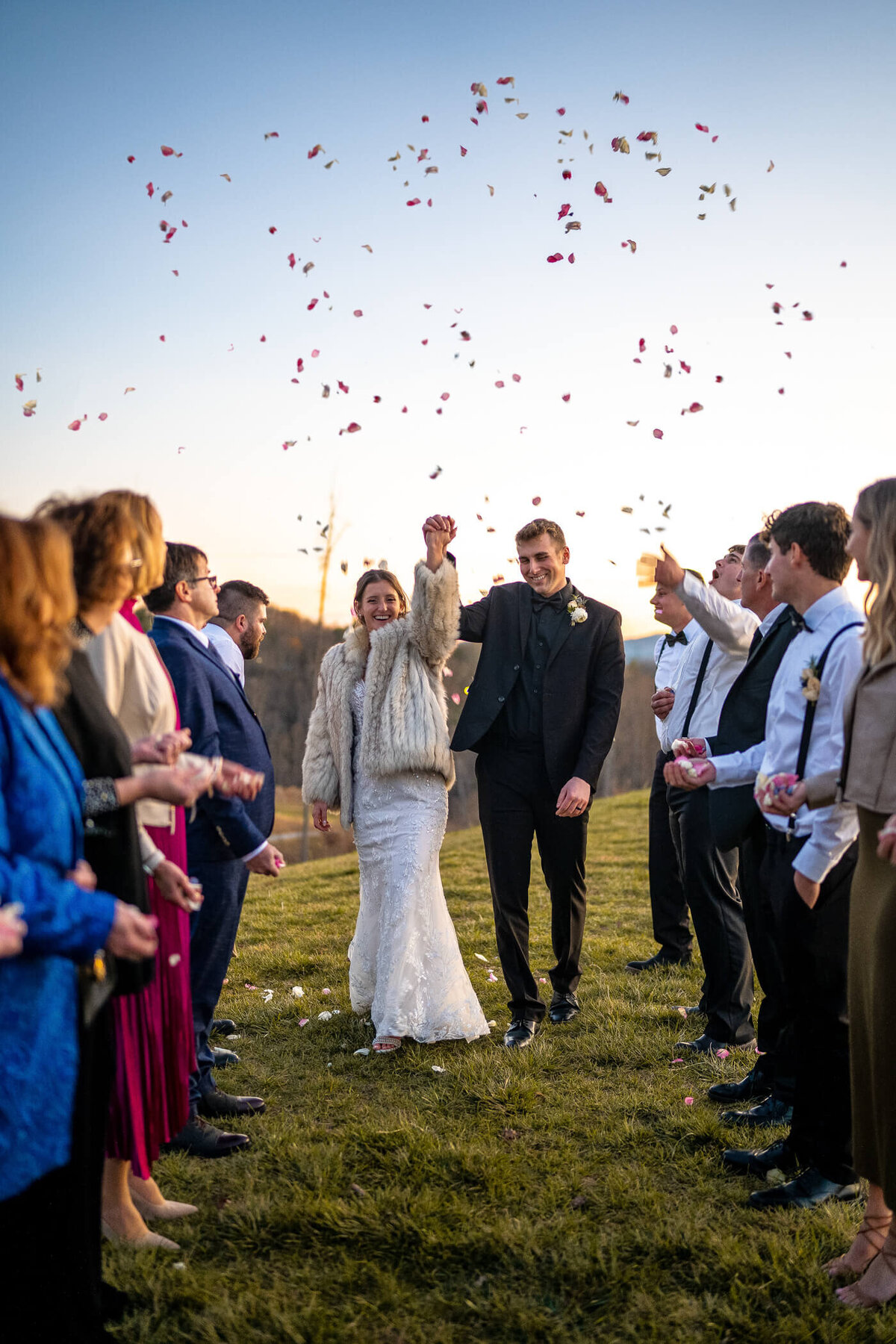 Bride and groom smile and hold hands during their flower petal exit and their intimate wedding at Marked Tree Vineyard in Ashville, NC. Wedding photography captured by Michael Fricke Photography