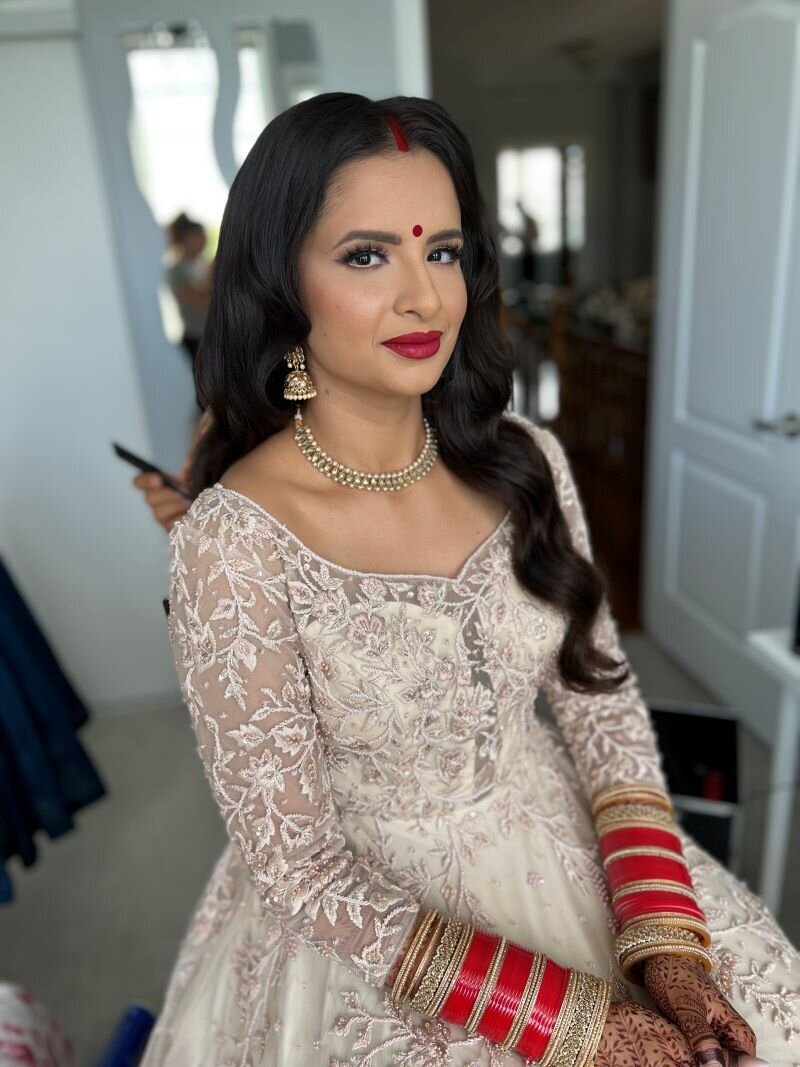 Stunning Indian bride in Ottawa featuring traditional kohl-lined eyes and a vibrant red lip for her ceremony.