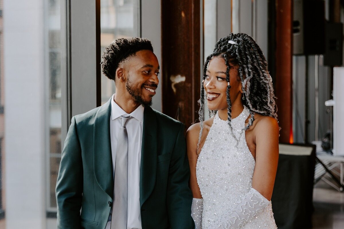 Bride and groom starring and smiling at each other