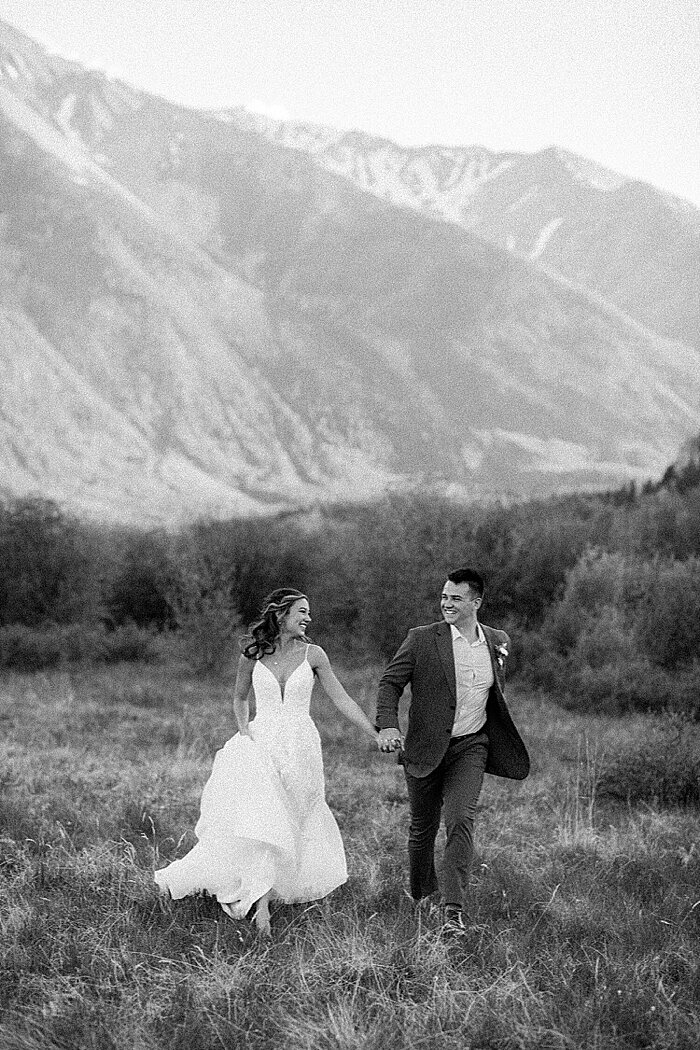 Colorado wedding photography of a candid wedding couple running through the mountains outside Denver