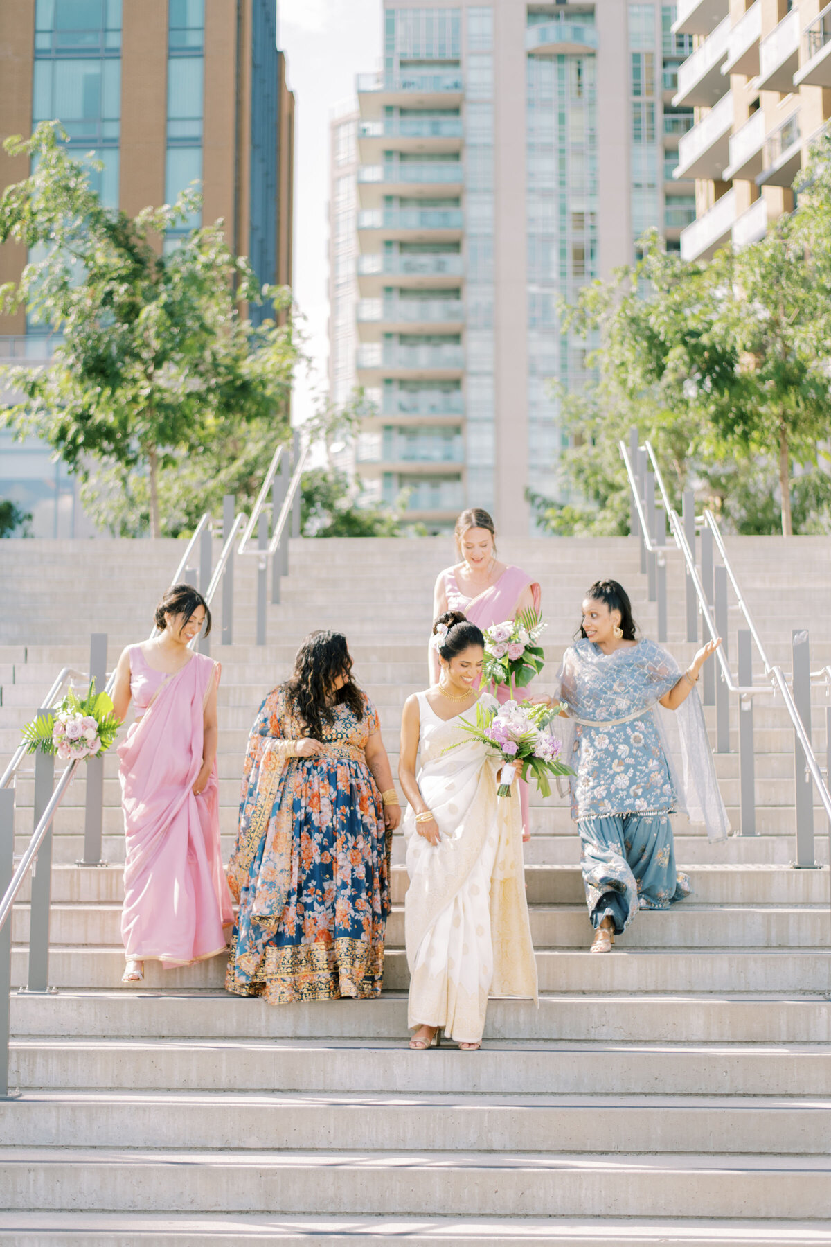Bridal party sharing a joyful moment, laughing together at The Pearle Hotel in Burlington during an Indian wedding.
