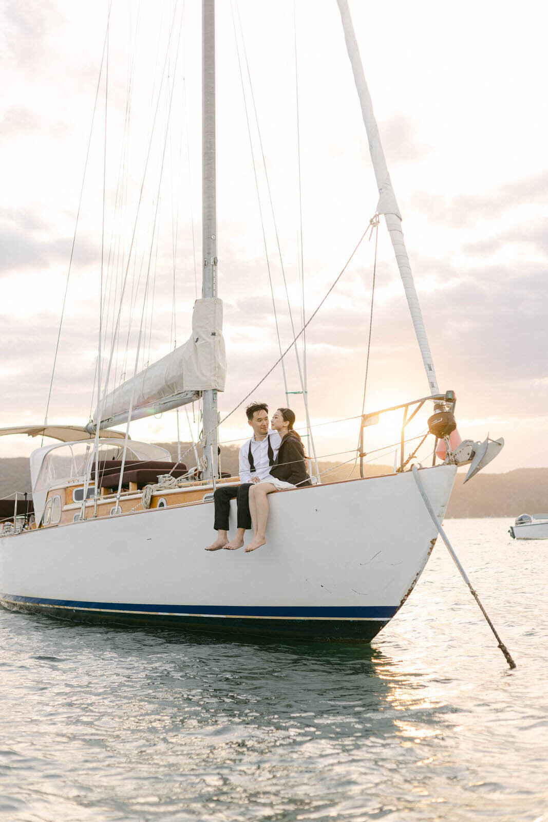 engaged couple sitting on a sailboat