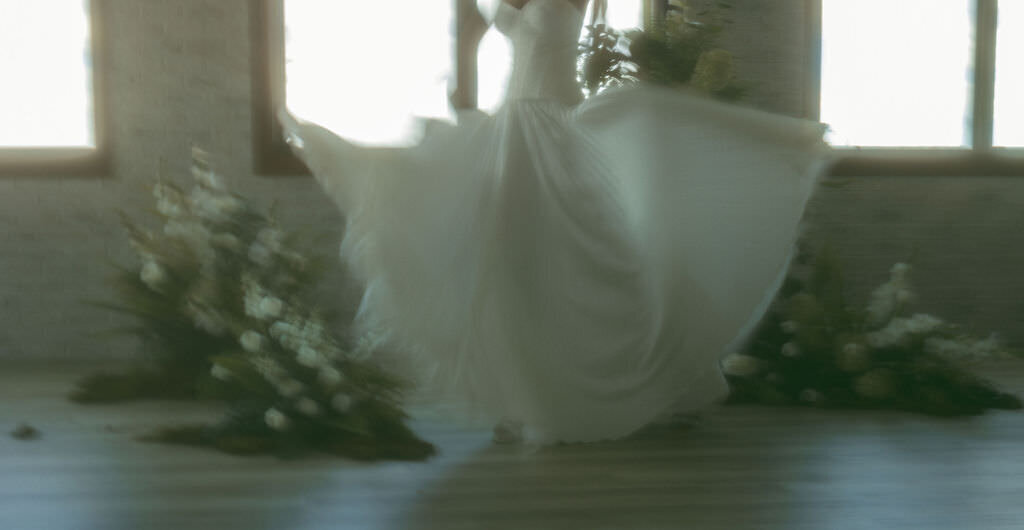 A person swinging the bottom of their wedding dress around.