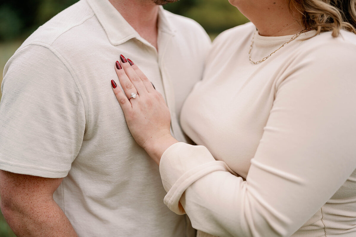 Close-up of the bride-to-be resting her hand on her partner’s arm during their Al Sabo Preserve engagement photos.