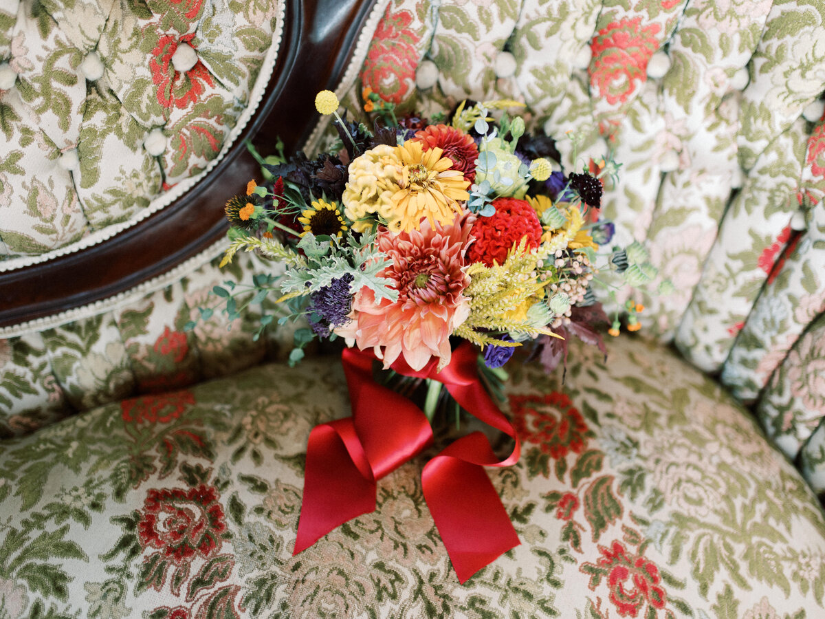 Fall bouquet sitting on a floral print chair