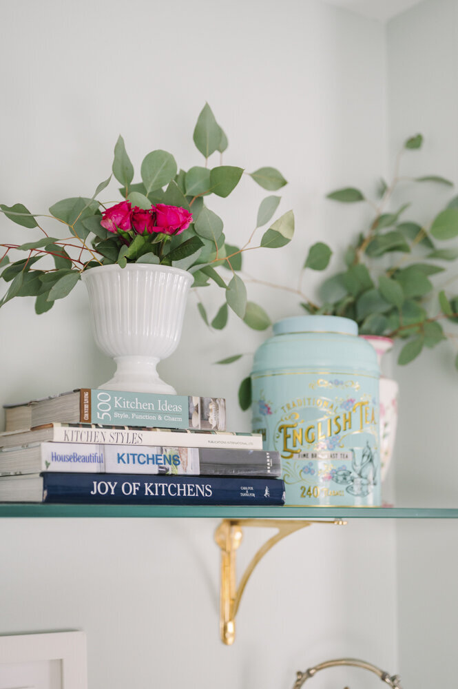 flowers and books sitting on a shelf
