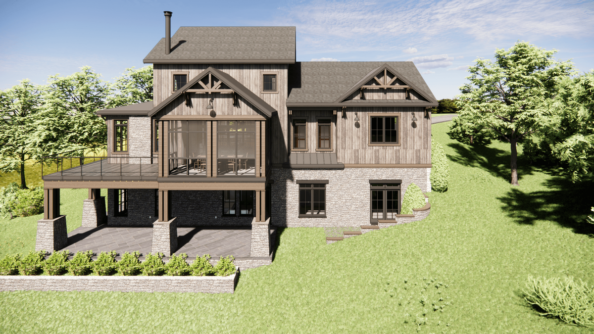 A rustic two-story house with wood and stone exterior, surrounded by green grass and trees. It features a steep roof, large windows, and a spacious covered deck. The sky is clear and sunny.