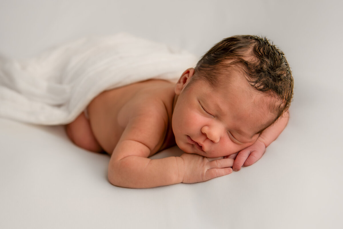 newborn baby boy sleeping on white background