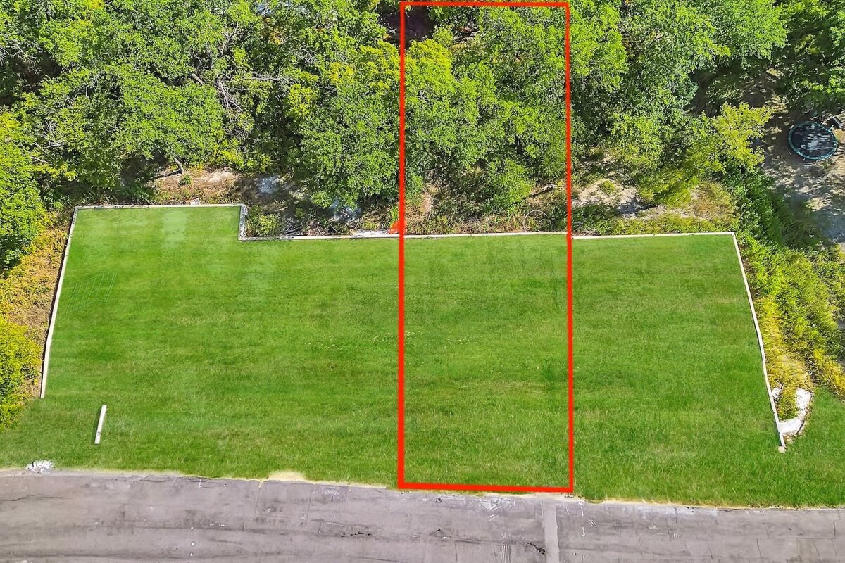 Rectangular residential lot in Dallas with mature trees lining the back, perfect for a private luxury build in a serene setting.