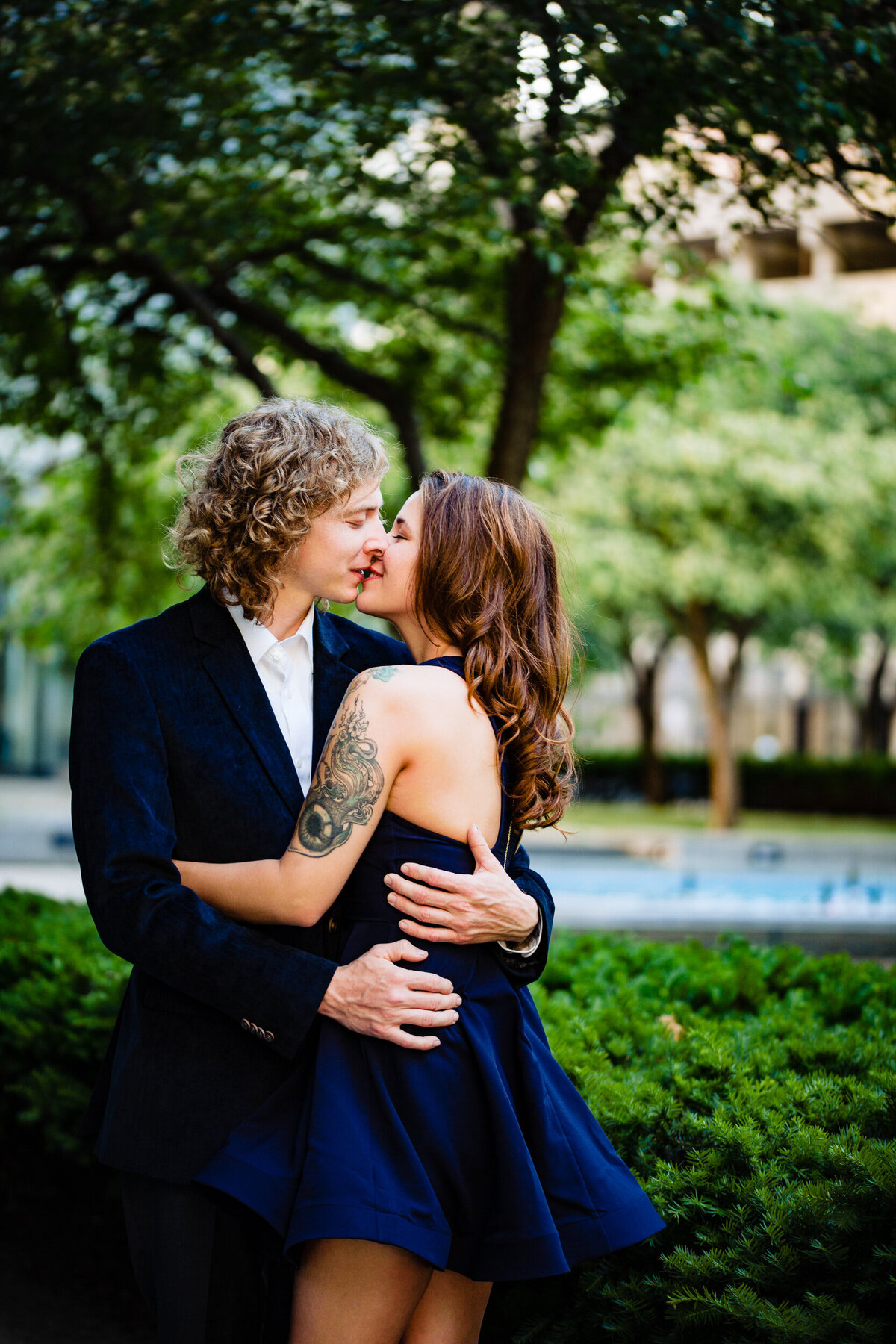 A couple kisses in Toledo Ohio under a tree while wearing blue.  Photo By Adore Wedding Photography. Toledo Wedding Photographers
